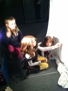The girls who designed the puppets above, with a young admirer. 