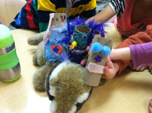 Three student made puppets hitch a ride on a chipmunk puppet that a teacher brought. 
